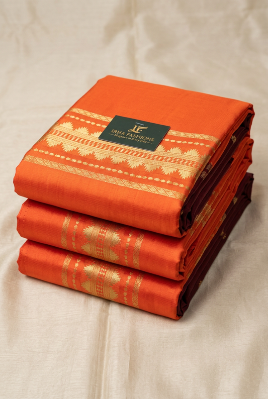 Orange soft silk saree neatly folded showing the gold zari border