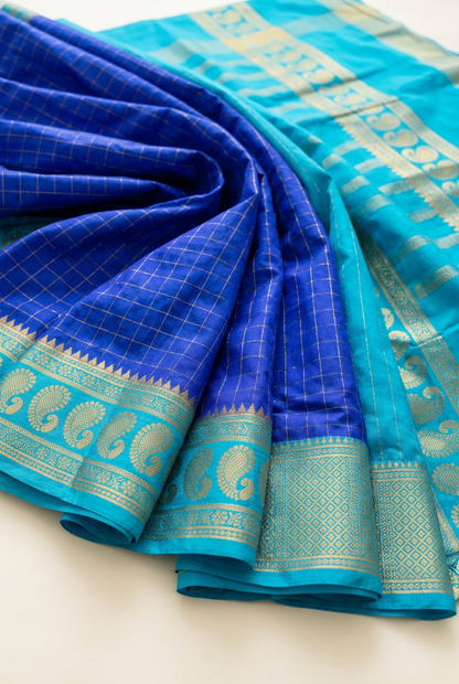 Royal blue saree fabric and turquoise gold-toned paisley border detail