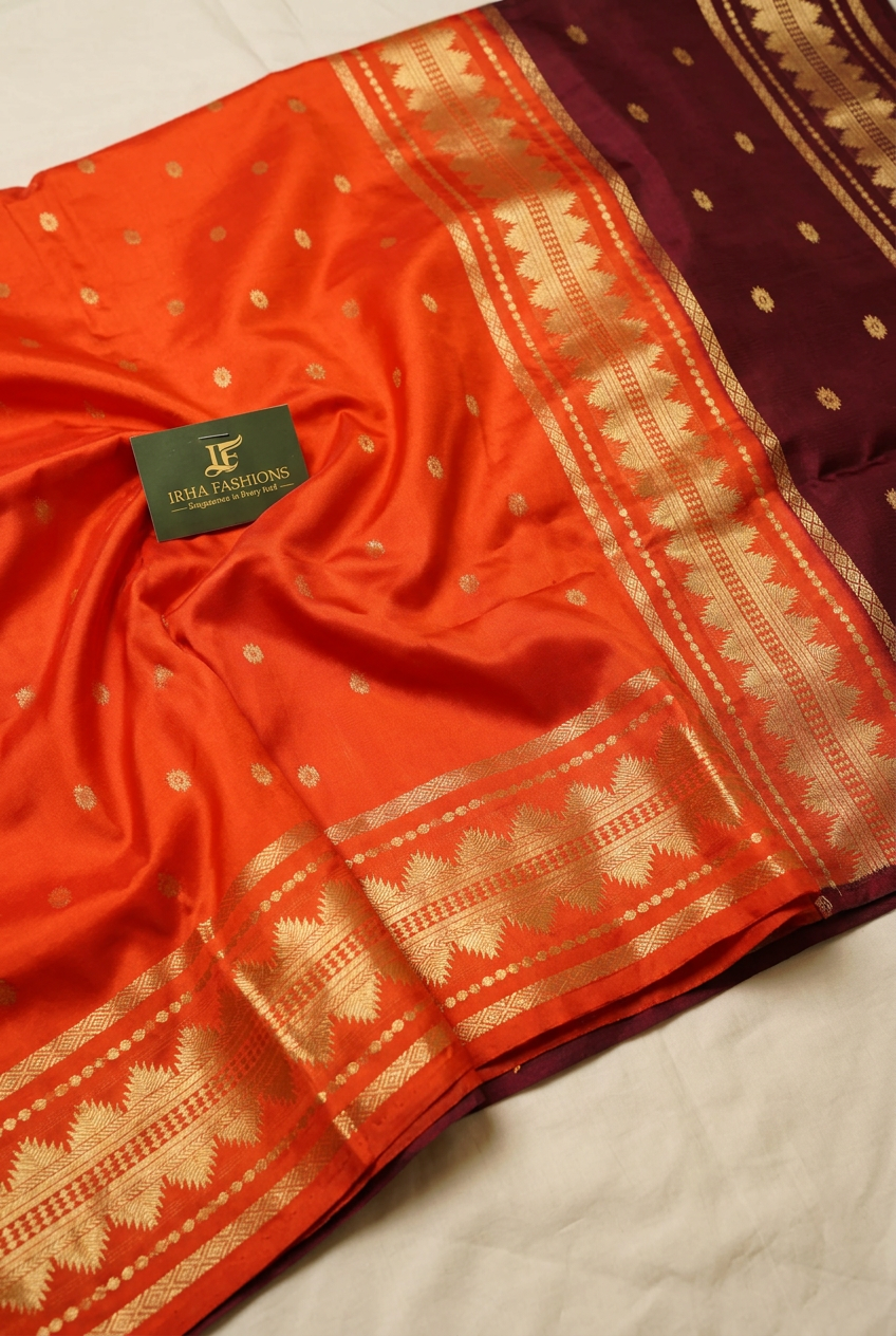 Side angle of the orange saree showing the gold zari temple border and dark maroon pallu edge